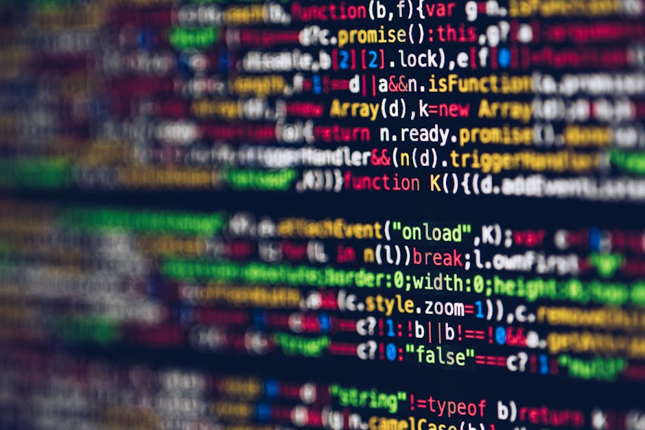A close-up digital photograph of a computer screen displaying lines of colourful programming code, including keywords, variables, functions, and syntax highlighted in shades of red, green, yellow, blu